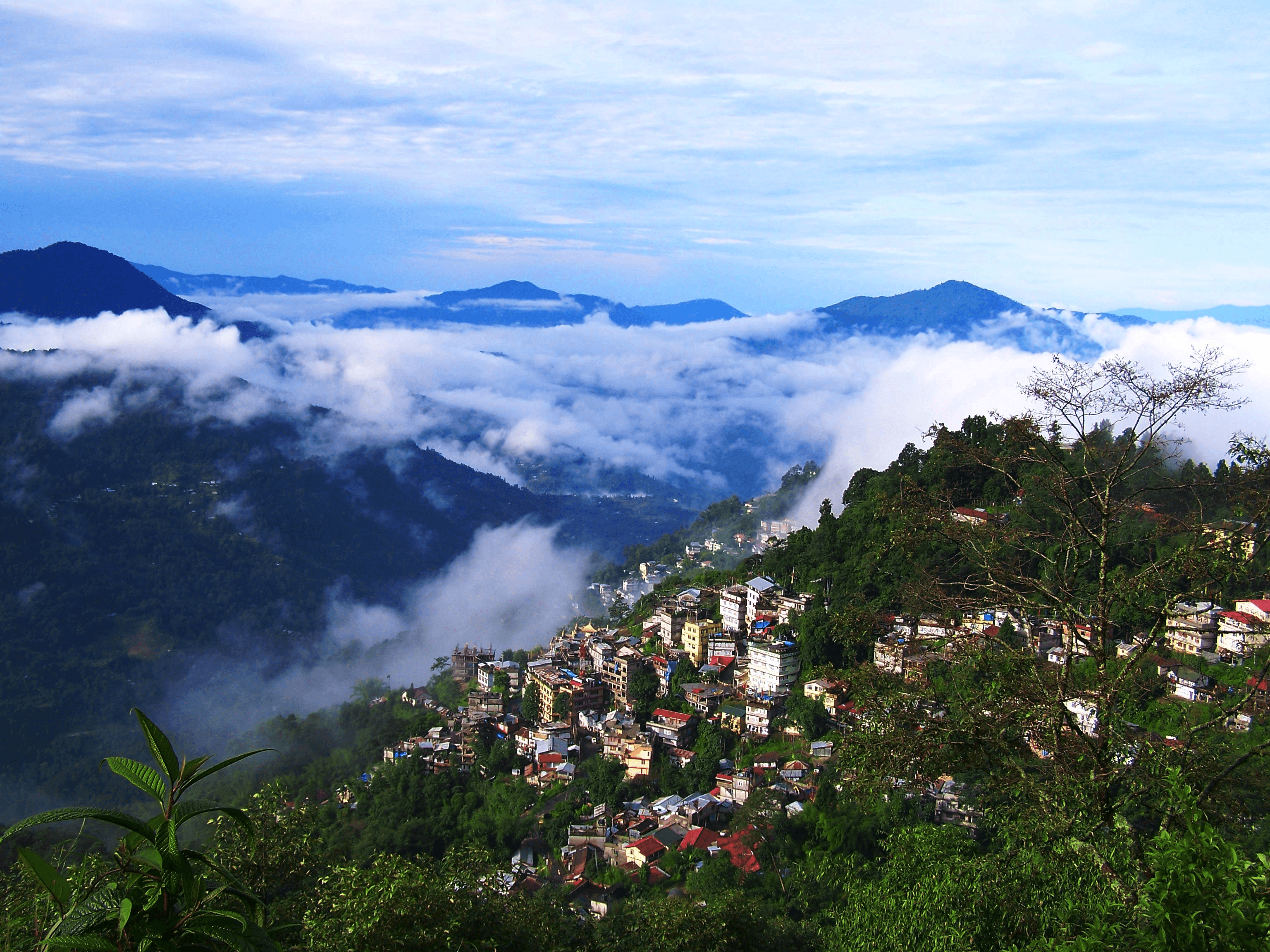 Gangtok city in Sikkim with colorful hillside buildings, Buddhist monasteries and views of Kangchenjunga in the Himalayas.