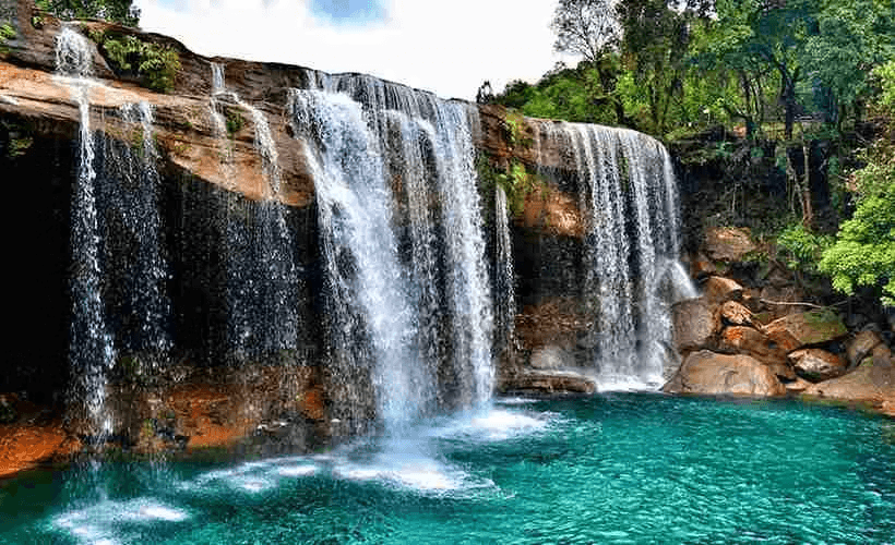 Krang Suri Falls in Jowai, Meghalaya with turquoise water surrounded by lush forest in the scenic Jaintia Hills.