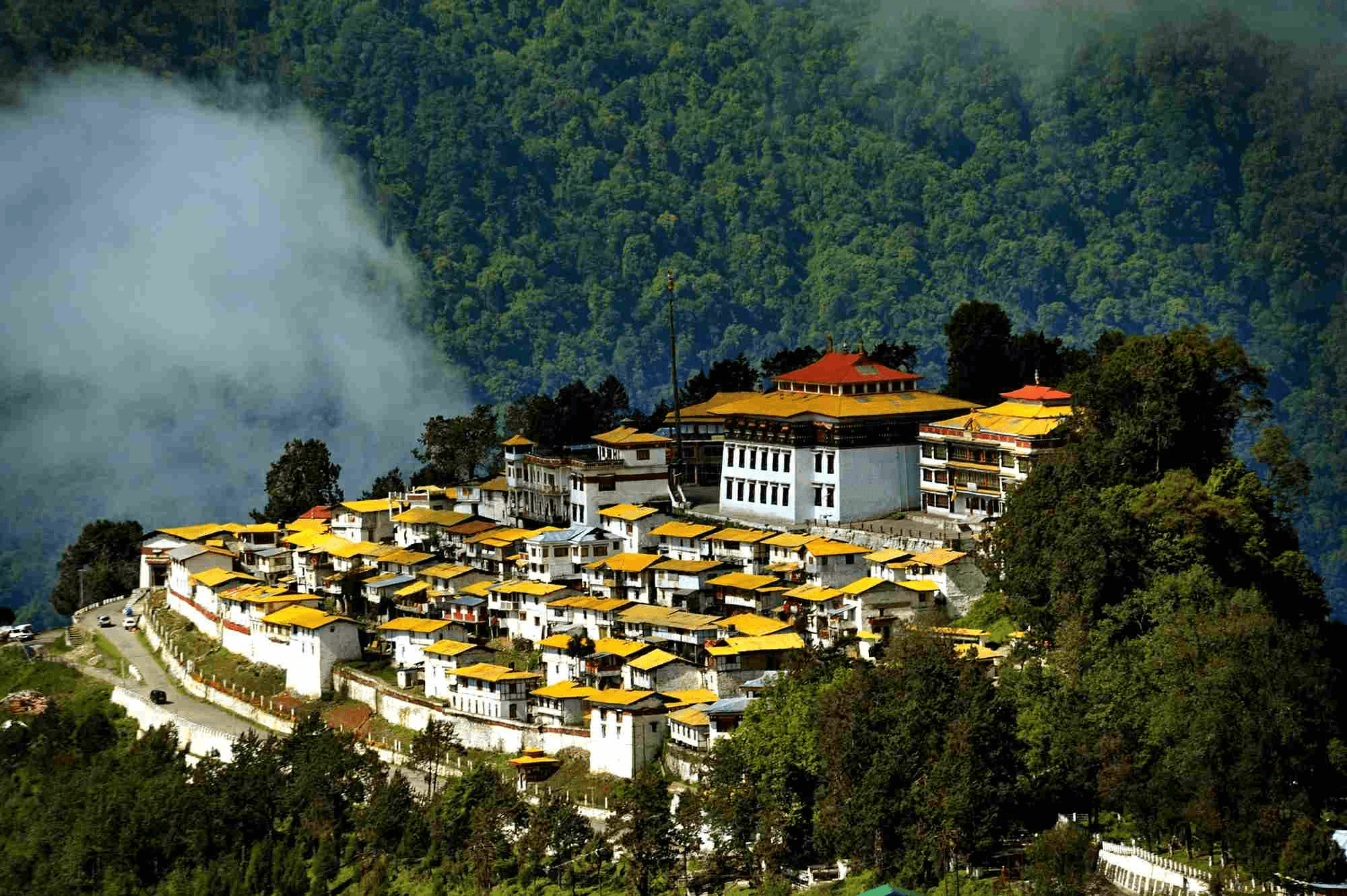 Alt Text Tawang Monastery perched on hilltop surrounded by Himalayan peaks and prayer flags in Arunachal Pradesh, Northeast India